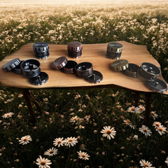 Collection of metal containers on a wooden table with a field of flowers in the background