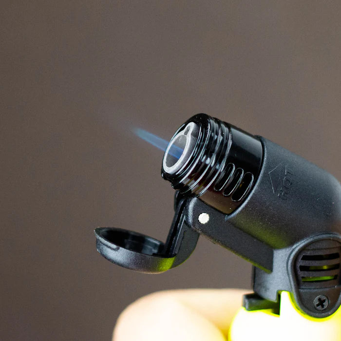 Close-up of Eagle Torch NEON PT116BN mini torch lighter with vibrant neon finish, showing a strong blue windproof jet flame in action.