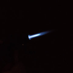 Eagle Torch PT116MOK mini torch lighter ignited, showing vivid blue jet flame against a black background – windproof flame in action.