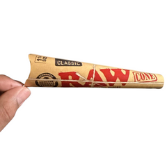 Hand holding a RAW Classic 1¼ Pre-Rolled Cone – Single Pack, 6 Cones in a pack, Water-Based Gumline for Perfect Seal, Clean Taste.